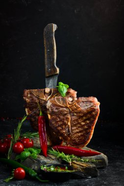 Siyah arka planda baharatlı ve otlu iki sulu ızgara biftek. Üst Manzara. Kırsal biçim.