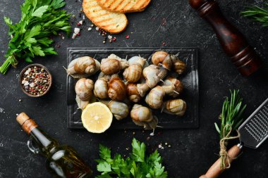 Fransız yemeği. Maydanozlu ve limonlu siyah taşlı salyangozlar. Üst Manzara. Metnin için boş yer.