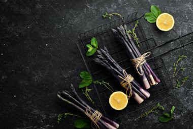 Siyah taşlı limonlu taze kuşkonmaz. Sağlıklı yiyecekler. Üst görünüm, ücretsiz kopyalama alanı.