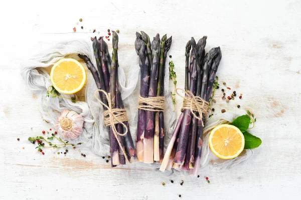 Beyaz ahşap arka planda çiğ kuşkonmaz demeti. Sağlıklı yiyecekler. Üst görünüm, ücretsiz kopyalama alanı.