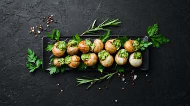 Sosla pişirilmiş salyangozlar. Tereyağı ve baharatlı fırında salyangoz. Üst Manzara. Metnin için boş yer.