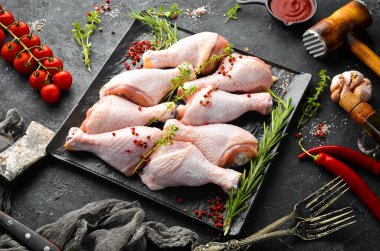 Siyah taşlı arka planda baharatlı çiğ tavuk budu. - Et. Üst Manzara. Kırsal biçim.