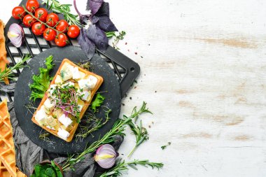Krem peynirli Belçika waffleları, beyaz peynir ve mavi peynir. Üst Manzara. Metnin için boş yer.