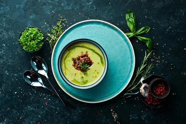 Green soup with bacon. Soup with broccoli, spinach and green peas. Top view. Rustic style.