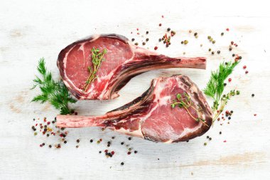 Kurumuş çiğ baltalı biftek. Kemiğe biftek. Beyaz ahşap bir arka planda. Üst Manzara. Boş kopyalama alanı.