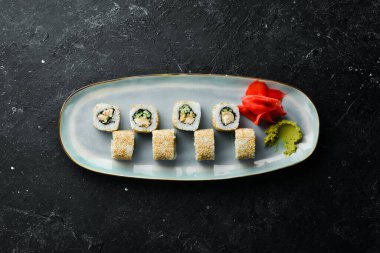 Salatalıklı rulo, tabakta balık ve peynir. Suşi. Üst Manzara. Kırsal biçim.