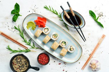 Salatalıklı rulo, tabakta balık ve peynir. Suşi. Üst Manzara. Kırsal biçim.