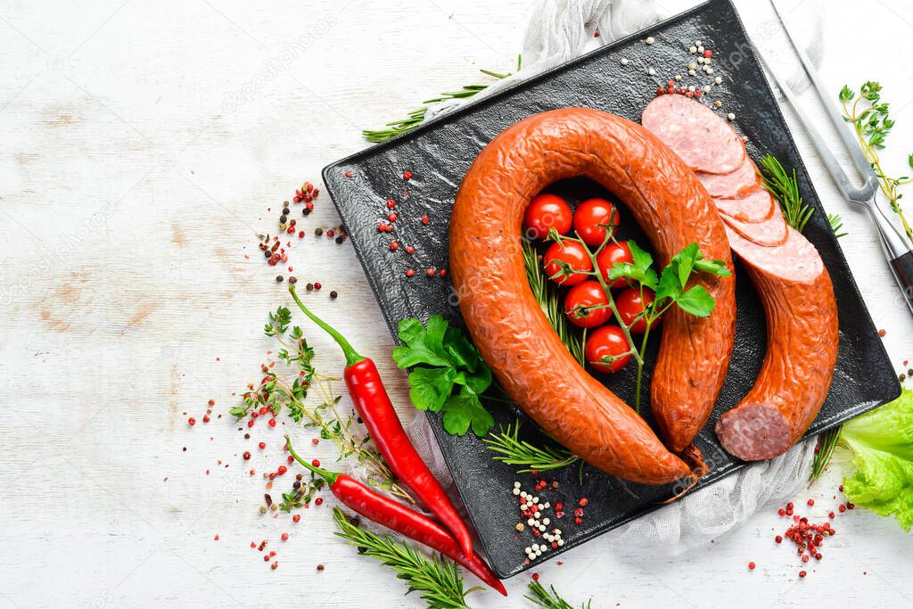 Smoked sausage ring with spices and herbs. Top view. Free space for text.