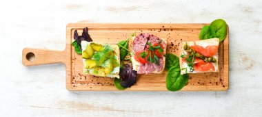 Tahta tahtada sebzeli ve somonlu sandviçler. Üst Manzara. Kırsal biçim.