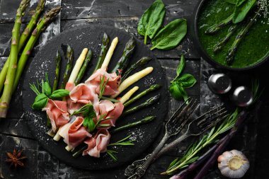 Haşlanmış kuşkonmaz ve siyah taş tabakta baharatlı jambon. Üst Manzara. Metnin için boş yer.