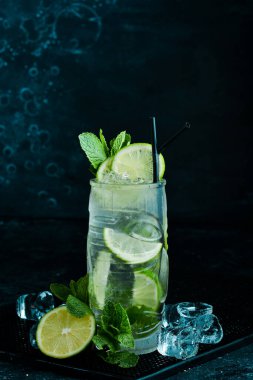 Naneli ve limonlu mojito kokteyli. Yaz iksiri kokteyli. Siyah taştan bir arka planda. Menü barı. Alkol..