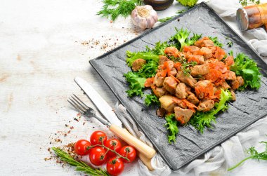 Siyah taş bir tabakta bira içinde sebzelerle pişirilmiş domuz eti. Üst Manzara. Eski arkaplan, köy tarzı.