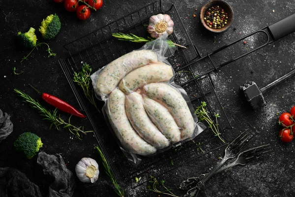 Raw pork sausages in vacuum packaging. Top view. On a black background.