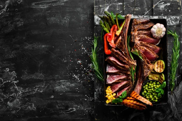 Sült Hús Csonton Két Szaftos Sült Borjústeak Zöldségekkel Fűszerekkel Fekete — Stock Fotó