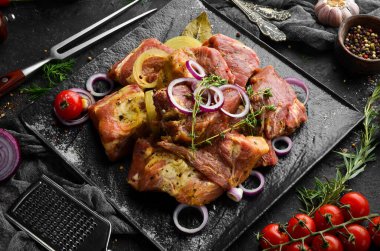 - Et. Çiğ salamura kebap soğan ve baharatla siyah tabakta. Üst Manzara. Boş kopyalama alanı.