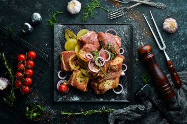 - Et. Çiğ salamura kebap soğan ve baharatla siyah tabakta. Üst Manzara. Boş kopyalama alanı.