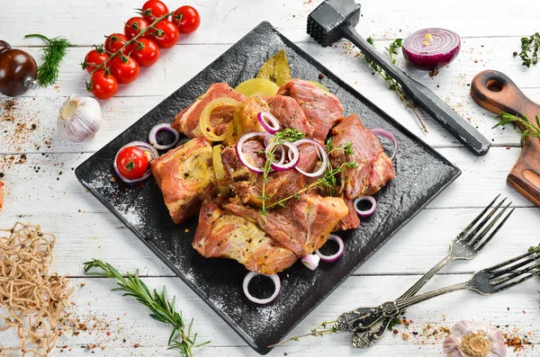 - Et. Çiğ salamura kebap soğan ve baharatla siyah tabakta. Üst Manzara. Boş kopyalama alanı.