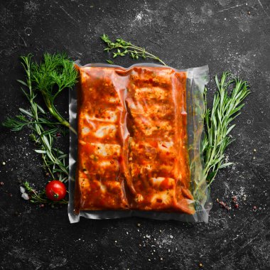 Barbekü. Biber soslu marine edilmiş domuz pirzolası ile vakum ambalajı. Üst Manzara. Metnin için boş yer.