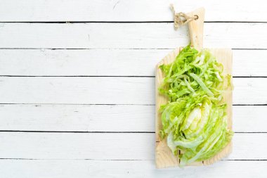 Beyaz ahşap arka planda marul. Yeşil sağlıklı yiyecek. Buzdağı marulu. Üst Manzara. Boş kopyalama alanı.