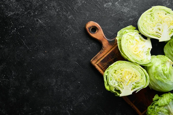 Buzdağı marulu. Siyah taşlı arka planda taze marul. Üst Manzara. Boş kopyalama alanı.