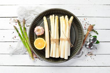 Beyaz ahşap arka planda organik beyaz kuşkonmaz. Sağlıklı yiyecekler. Üst Manzara. Metnin için boş yer.