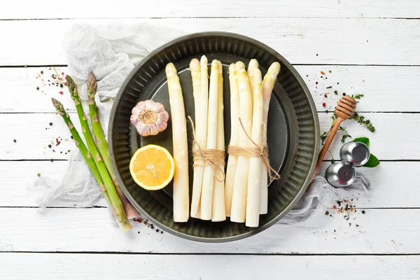 Beyaz ahşap arka planda organik beyaz kuşkonmaz. Sağlıklı yiyecekler. Üst Manzara. Metnin için boş yer.