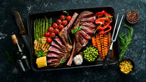 Izgara biftek ve ızgara sebze: kuşkonmaz, mısır, kabak, havuç ve biberiye. Tomahawk. Üst Manzara. Boş kopyalama alanı.