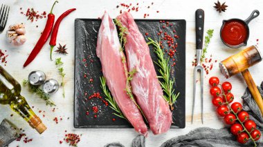 Beyaz ahşap arka planda baharatlı çiğ domuz filetosu. - Et. Üst Manzara. Kırsal biçim.