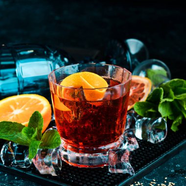 Siyah taş arka planda geleneksel Negroni kokteyli. Menü barı. Alkol..