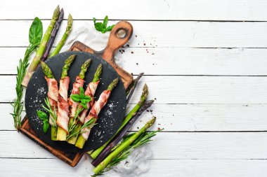 Domuz pastırması ve baharatla pişirilmiş kuşkonmaz. Üst Manzara. Metnin için boş yer.