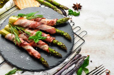 Domuz pastırması ve baharatla pişirilmiş kuşkonmaz. Üst Manzara. Metnin için boş yer.