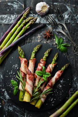 Domuz pastırması ve baharatla pişirilmiş kuşkonmaz. Üst Manzara. Metnin için boş yer.