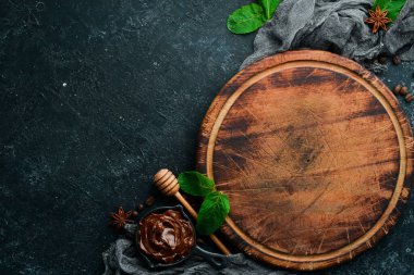 Siyah taş bir masanın üzerinde eski bir mutfak tahtası. Üst görünüm, ücretsiz kopyalama alanı.