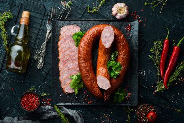 Siyah taşlı arka planda kurutulmuş domuz salamı sosis halkası. Üst Manzara. Metin için boş alan.