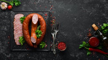 Siyah taşlı arka planda kurutulmuş domuz salamı sosis halkası. Üst Manzara. Metin için boş alan.