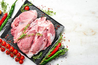 Boynundan taze çiğ domuz eti, mutfak arka planında malzemeler ve baharatlar var. - Et. Üst Manzara. Kırsal biçim.