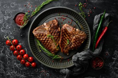 Siyah arka planda metal bir tencerede baharatlı ızgara biftek. Üst Manzara. Kırsal biçim.