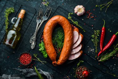 Taze pişmiş sosis. Siyah taşlı arka planda salam. Üst Manzara. Metin için boş alan.