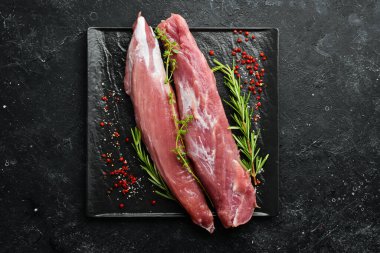 - Et. Siyah taşlı arka planda baharatlı çiğ domuz filetosu. Üst Manzara. Kırsal biçim.