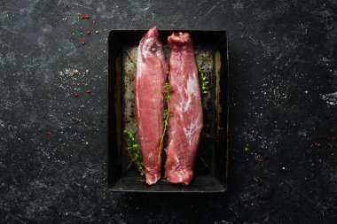 - Et. Siyah taşlı arka planda baharatlı çiğ domuz filetosu. Üst Manzara. Kırsal biçim.