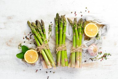 Beyaz ahşap arka planda taze yeşil kuşkonmaz. Sağlıklı yiyecekler. Üst görünüm, ücretsiz kopyalama alanı.