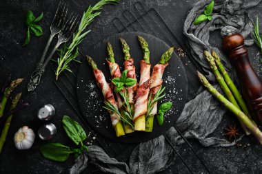 Domuz pastırması ve baharatla pişirilmiş kuşkonmaz. Üst Manzara. Metnin için boş yer.