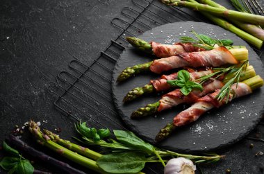 Domuz pastırması ve baharatla pişirilmiş kuşkonmaz. Üst Manzara. Metnin için boş yer.