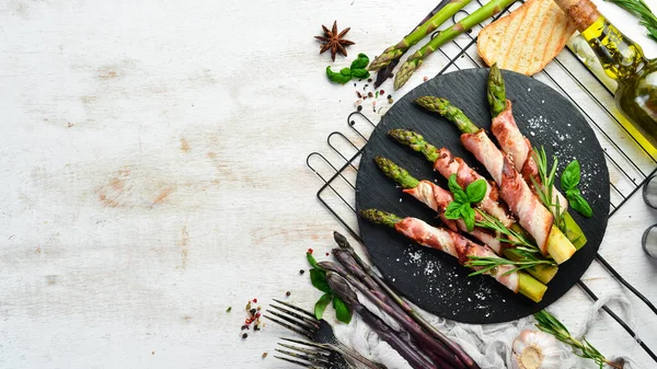 Domuz pastırması ve baharatla pişirilmiş kuşkonmaz. Üst Manzara. Metnin için boş yer.