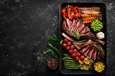 Izgara biftek ve ızgara sebze: kuşkonmaz, mısır, kabak, havuç ve biberiye. Tomahawk. Üst Manzara. Boş kopyalama alanı.