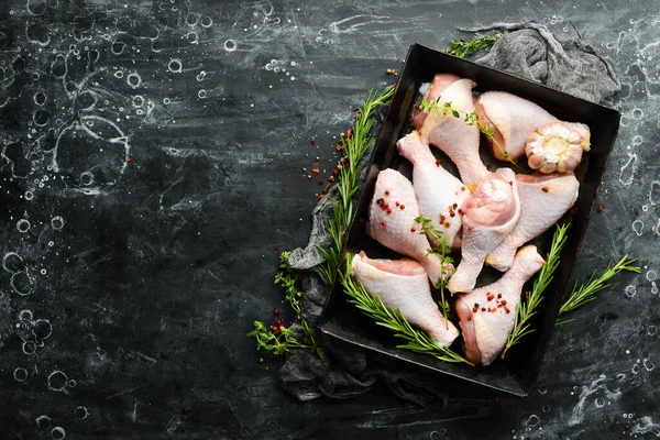 Siyah taşlı arka planda baharatlı çiğ tavuk budu. - Et. Üst Manzara. Kırsal biçim.