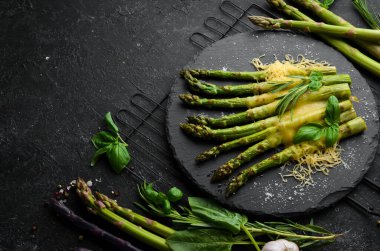 Siyah taş tabakta peynirli ve fesleğenli kuşkonmaz. Üst Manzara. Metnin için boş yer.