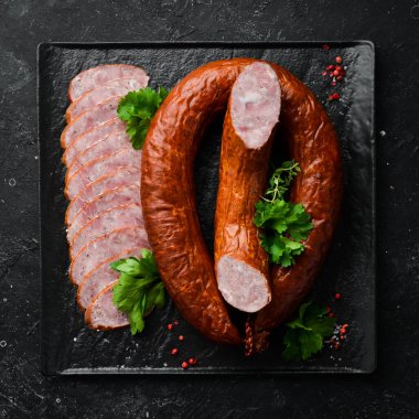 Siyah taşlı arka planda kurutulmuş domuz salamı sosis halkası. Üst Manzara. Metin için boş alan.