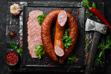 Siyah taşlı arka planda kurutulmuş domuz salamı sosis halkası. Üst Manzara. Metin için boş alan.