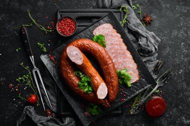 Siyah taşlı arka planda kurutulmuş domuz salamı sosis halkası. Üst Manzara. Metin için boş alan.